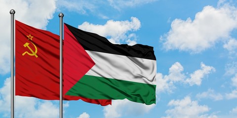 Soviet Union and Palestine flag waving in the wind against white cloudy blue sky together....