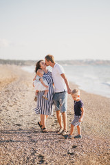 Happy family having fun near sea at the beach.