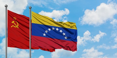Soviet Union and Venezuela flag waving in the wind against white cloudy blue sky together. Diplomacy concept, international relations.