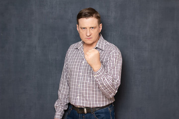 Obraz premium Portrait of angry irritated man raising hand with clenched fist