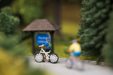 Naklejka premium Small figurine of man with bicycle.