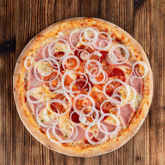 Italian pizza with pork ham, red onions and hot melted cheese