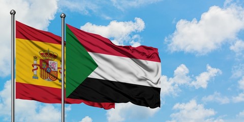 Spain and Sudan flag waving in the wind against white cloudy blue sky together. Diplomacy concept,...