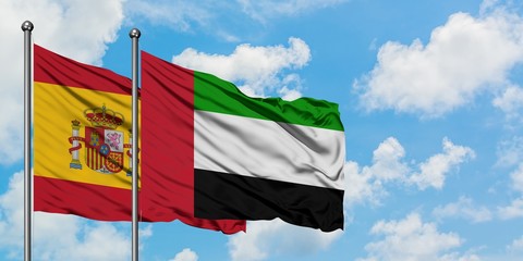 Spain and United Arab Emirates flag waving in the wind against white cloudy blue sky together. Diplomacy concept, international relations.