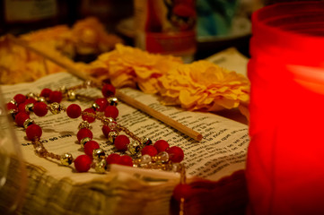 Worn pages of an open Bible book and a rosary beads.