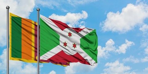 Sri Lanka and Burundi flag waving in the wind against white cloudy blue sky together. Diplomacy...