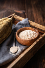 Organic baobab powder in a wooden bowl, healthy sport nutrition rich in vitamins and minerals