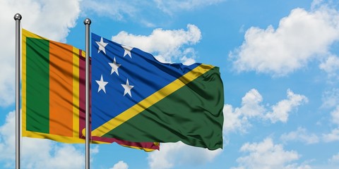 Sri Lanka and Solomon Islands flag waving in the wind against white cloudy blue sky together. Diplomacy concept, international relations.