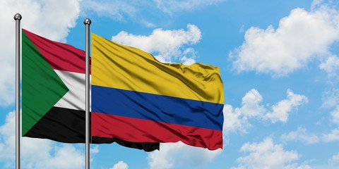 Sudan and Colombia flag waving in the wind against white cloudy blue sky together. Diplomacy concept, international relations.