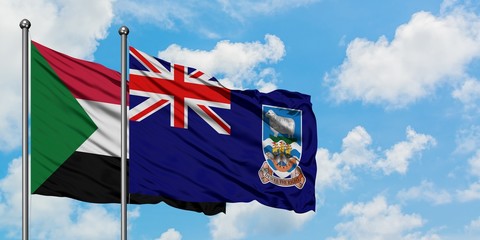 Sudan and Falkland Islands flag waving in the wind against white cloudy blue sky together. Diplomacy concept, international relations.