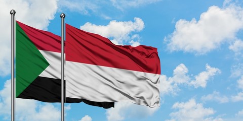 Sudan and Indonesia flag waving in the wind against white cloudy blue sky together. Diplomacy concept, international relations.