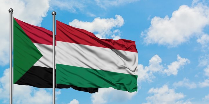 Sudan and Hungary flag waving in the wind against white cloudy blue sky together. Diplomacy concept, international relations.