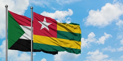 Sudan and Togo flag waving in the wind against white cloudy blue sky together. Diplomacy concept, international relations.