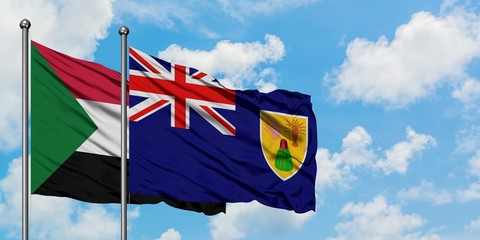 Sudan and Turks And Caicos Islands flag waving in the wind against white cloudy blue sky together. Diplomacy concept, international relations.