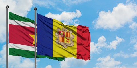Suriname and Andorra flag waving in the wind against white cloudy blue sky together. Diplomacy concept, international relations.