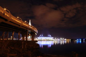 Fototapeta na wymiar colorful night cityscape with illuminated bridge over river