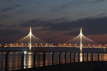 Fototapeta na wymiar observation deck on the shore with a view of the cable-stayed bridge and sunset