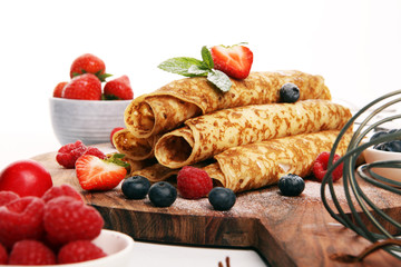 Delicious Tasty Homemade crepes or pancakes with raspberries and mint on rustic background