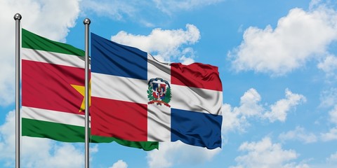 Suriname and Dominican Republic flag waving in the wind against white cloudy blue sky together. Diplomacy concept, international relations.