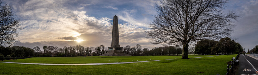 DUBLIN, IRELAND, DECEMBER 21, 2018: Beautiful panoramic view of Phoenix Park and Wellington Monument obelisk, also known as the Wellington Testimonial, during sunset on a colorful partly cloudy day.