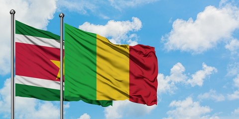 Suriname and Mali flag waving in the wind against white cloudy blue sky together. Diplomacy concept, international relations.