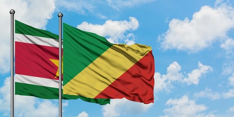 Suriname and Republic Of The Congo flag waving in the wind against white cloudy blue sky together. Diplomacy concept, international relations.