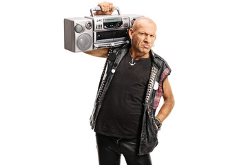 Grumpy punker carrying a boombox radio on his shoulder