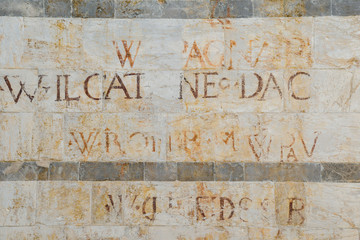 Exterior marble wall of the Church of St Michele in Borgo with jovial written executed in 1558 on the occasion of the election of the rector of the University, Pisa, Tuscany, Italy