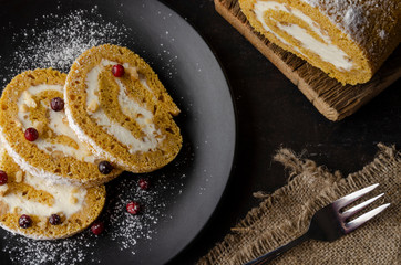 Pumpkin Roll with powdered sugar with walnuts pumpkin seeds and lingonberry. Top view.