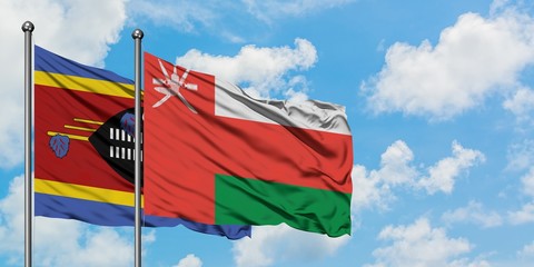 Swaziland and Oman flag waving in the wind against white cloudy blue sky together. Diplomacy concept, international relations.