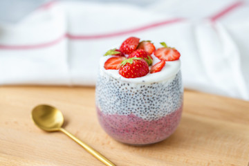 Chia pudding with almond milk, yogurt, pitaya powder and strawberries. Vegan concept.