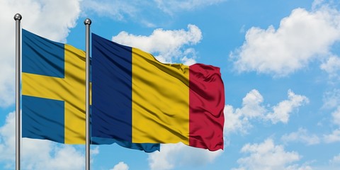 Sweden and Chad flag waving in the wind against white cloudy blue sky together. Diplomacy concept, international relations.