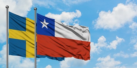 Sweden and Chile flag waving in the wind against white cloudy blue sky together. Diplomacy concept, international relations.