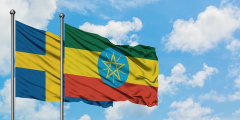 Sweden and Ethiopia flag waving in the wind against white cloudy blue sky together. Diplomacy concept, international relations.