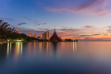 Fototapeta na wymiar The Sanctuary of Truth (Prasat Mai), Pattaya, Thailand And tall buildings in Pattaya At sunset