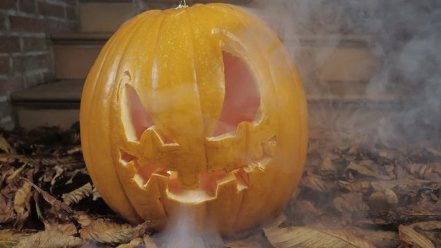 25% of realtime slow motion shot of halloween pumpkins with smoke in front of a house
