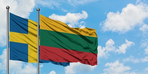 Sweden and Lithuania flag waving in the wind against white cloudy blue sky together. Diplomacy concept, international relations.
