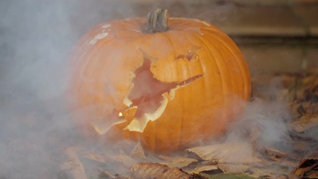 20% of realtime slow motion shot of halloween pumpkins with smoke in front of a house