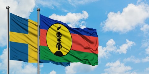 Sweden and New Caledonia flag waving in the wind against white cloudy blue sky together. Diplomacy concept, international relations.