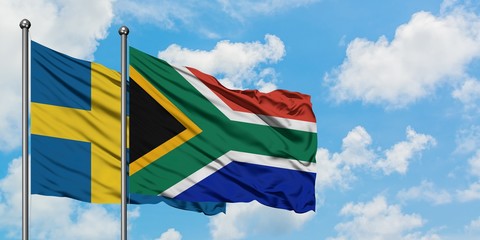 Sweden and South Africa flag waving in the wind against white cloudy blue sky together. Diplomacy concept, international relations.