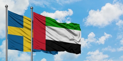 Sweden and United Arab Emirates flag waving in the wind against white cloudy blue sky together. Diplomacy concept, international relations.