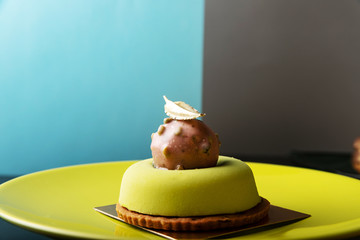 Green modern round mousse dessert on glossy table