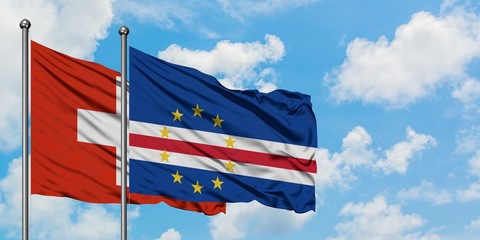 Switzerland and Cape Verde flag waving in the wind against white cloudy blue sky together. Diplomacy concept, international relations.