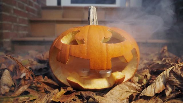 25% of realtime slow motion shot of halloween pumpkins with smoke in front of a house