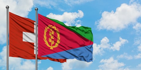 Switzerland and Eritrea flag waving in the wind against white cloudy blue sky together. Diplomacy concept, international relations.