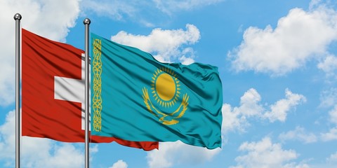 Switzerland and Kazakhstan flag waving in the wind against white cloudy blue sky together. Diplomacy concept, international relations.
