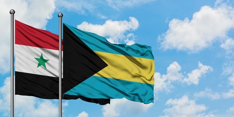 Syria and Bahamas flag waving in the wind against white cloudy blue sky together. Diplomacy...