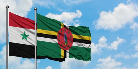 Syria and Dominica flag waving in the wind against white cloudy blue sky together. Diplomacy...