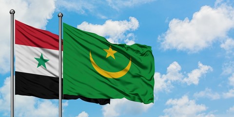 Syria and Mauritania flag waving in the wind against white cloudy blue sky together. Diplomacy...