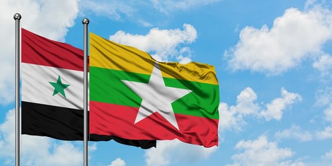 Syria and Myanmar flag waving in the wind against white cloudy blue sky together. Diplomacy concept, international relations.